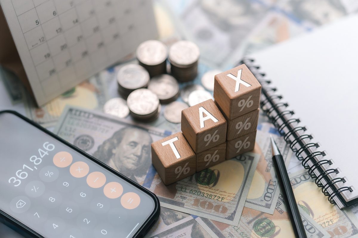 Tax planning concept, interest rates, wooden blocks with the word tax, calculator to calculate interest, financial calculations, tax law, tax payment, government taxes and budget planning.